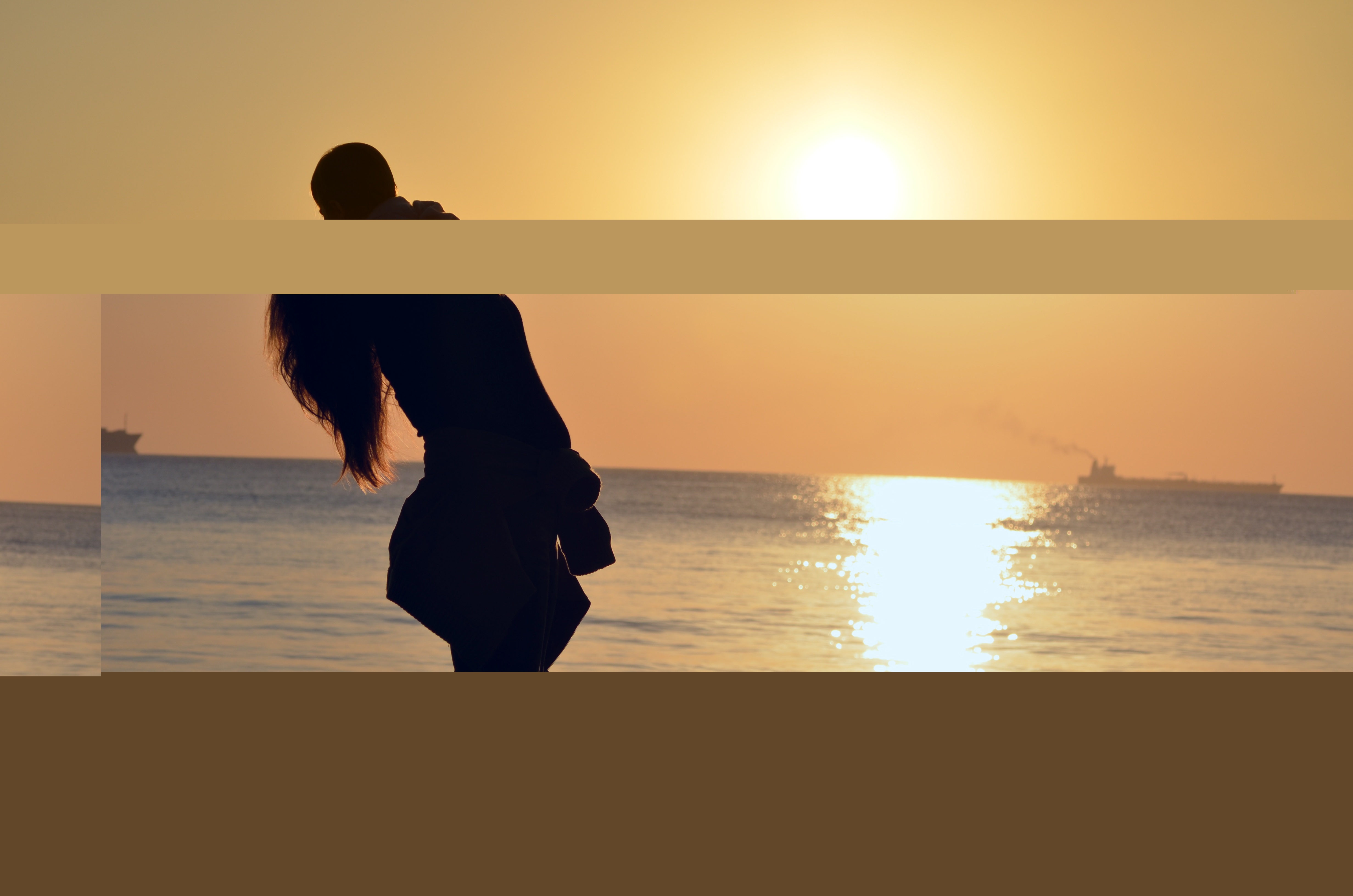 夕阳下妈妈抱着孩子笑